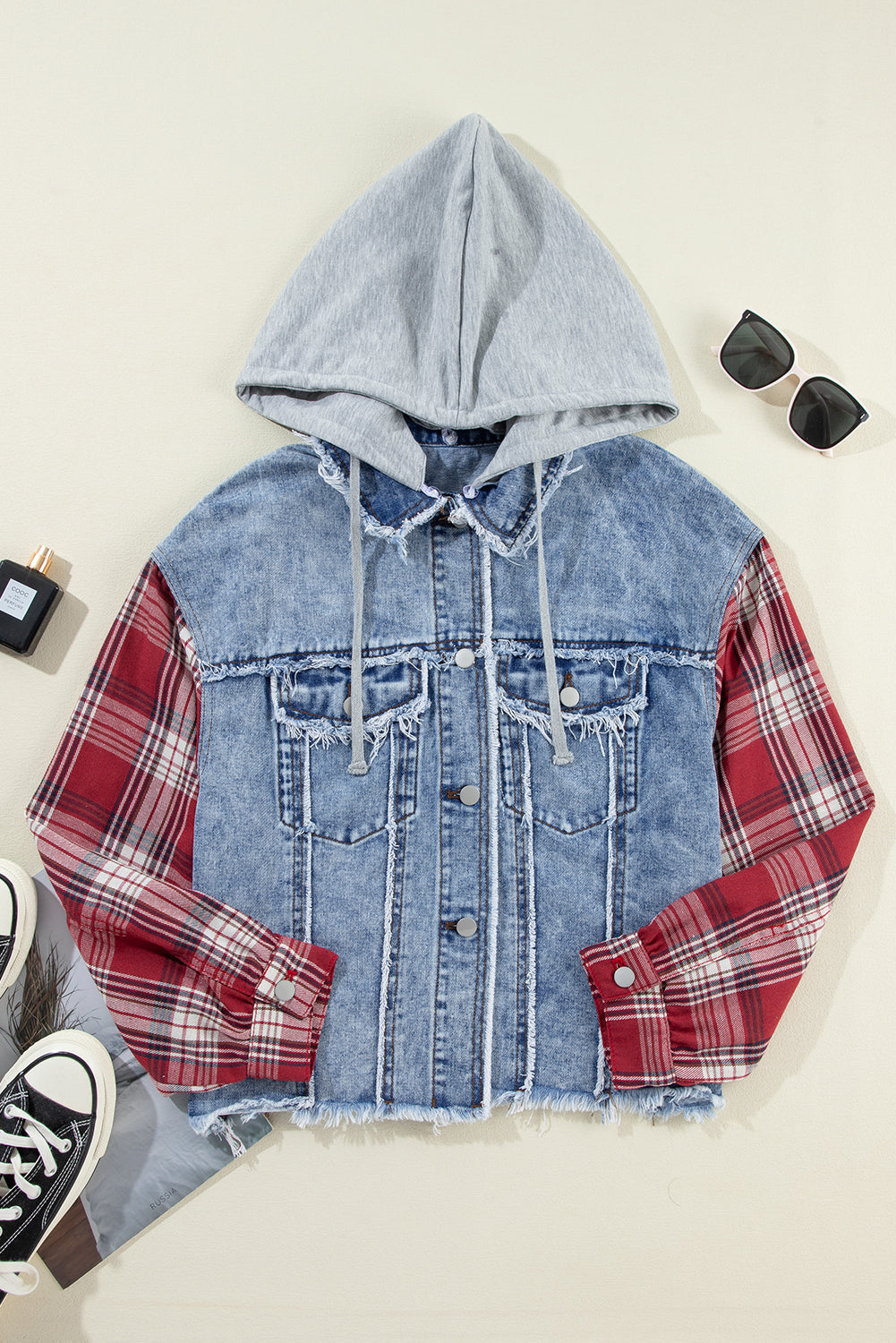 denim jacket with red and white plaid sleeves, flap pockets, hood, and button up closure. Front flat lay view