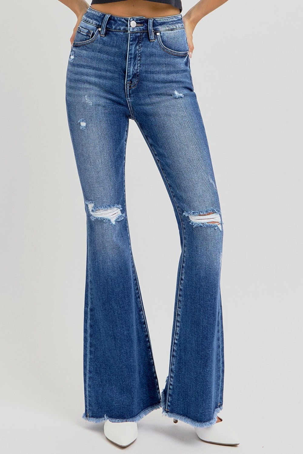 The Risen high rise distressed raw hem flare jeans are a trendy and stylish addition to your wardrobe. Featuring a flattering high-rise fit, these jeans offer a comfortable and supportive silhouette. The distressed detailing adds a touch of edge, while the raw hem gives them a modern, unfinished look. The flare leg creates a retro vibe, making them perfect for pairing with ankle boots or heels. Ideal for casual outings or dressed-up occasions, these jeans combine style with versatility! Front view