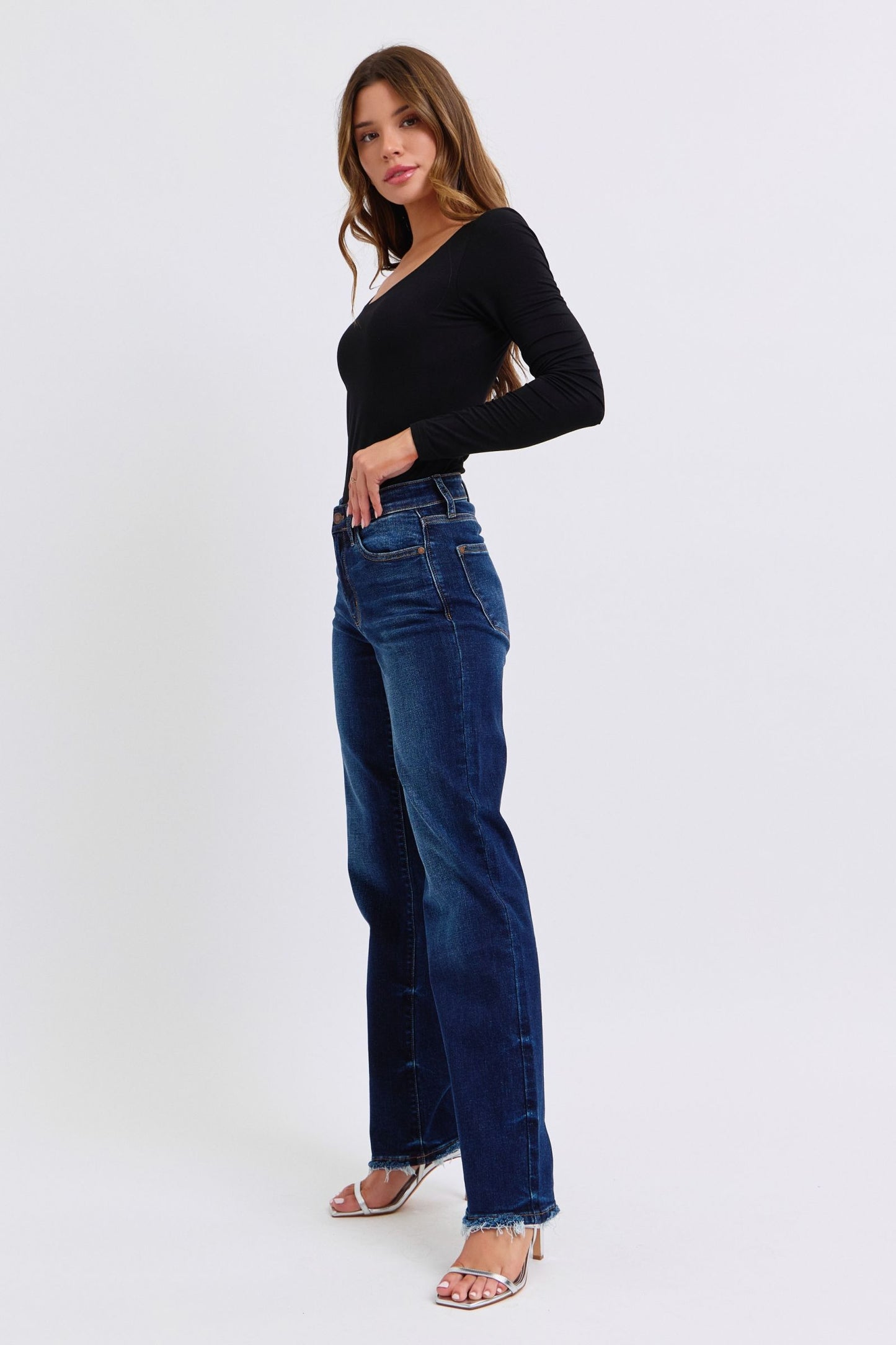 Judy Blue Raw Hem Straight Leg Jeans are a versatile and timeless addition to your wardrobe. The raw hem adds a touch of edge, while the straight leg style offers a flattering silhouette. Perfect for both casual and dressy looks, these jeans are a must-have for any fashion-forward individual. Front left angle view
