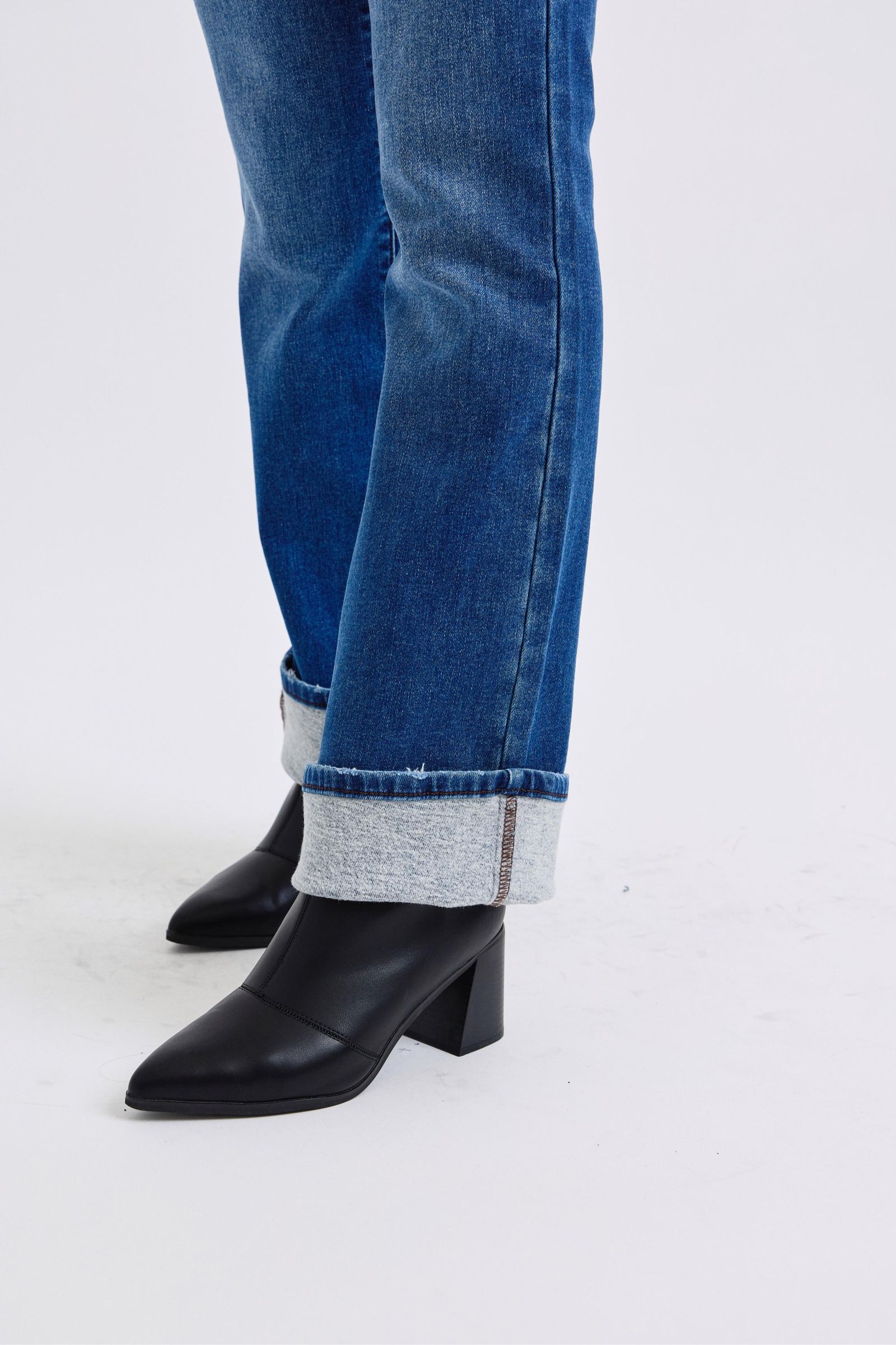 Judy Blue Mid-Rise Bootcut Jeans with thermal Lining. Featuring a mid-rise waist that offers a comfortable and flattering fit, these jeans accentuate the natural waistline. 
The bootcut silhouette flares slightly at the leg opening, creating a classic and elongating look. 
Designed with a thin thermal lining, these jeans provide lightweight warmth, making them perfect for cooler days. Close-up of hem