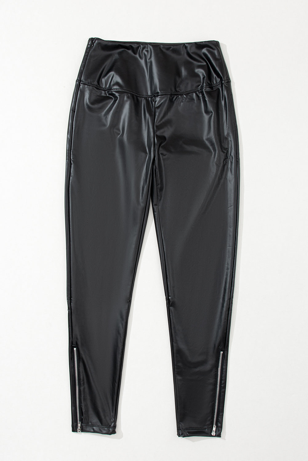 The Faux Leather Zipper Detail High Waist Leggings - Black are displayed on a light gray background. These leggings have a shiny finish and sport zipper details at the ankles for added style. They are smooth and fitted, crafted for a sleek appearance.