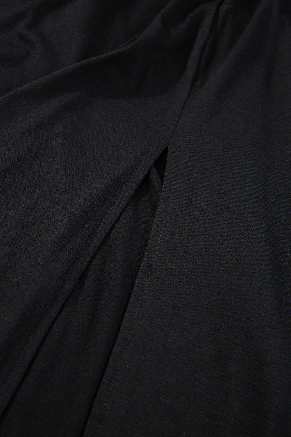 black Maxi Dress with Short Sleeves, Shirred High Waist, V Neck. Close up of leg slit