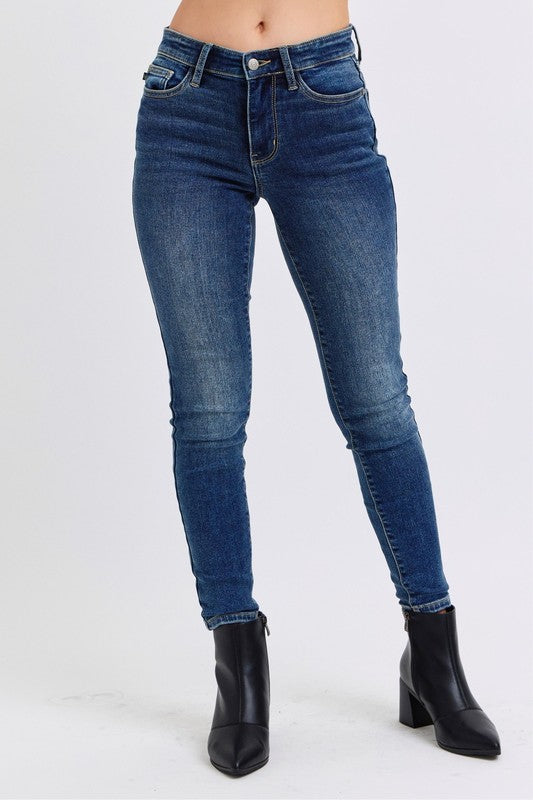 Judy Blue Mid-Rise Waist Skinny Jeans with Pockets are a versatile and essential piece for any wardrobe. With a flattering mid-rise waist and slimming skinny fit, these jeans create a sleek and stylish look. 
The addition of a thin thermal lining provides lightweight warmth, making them perfect for cooler days, while the pockets offer both functionality and casual flair.  Front view

