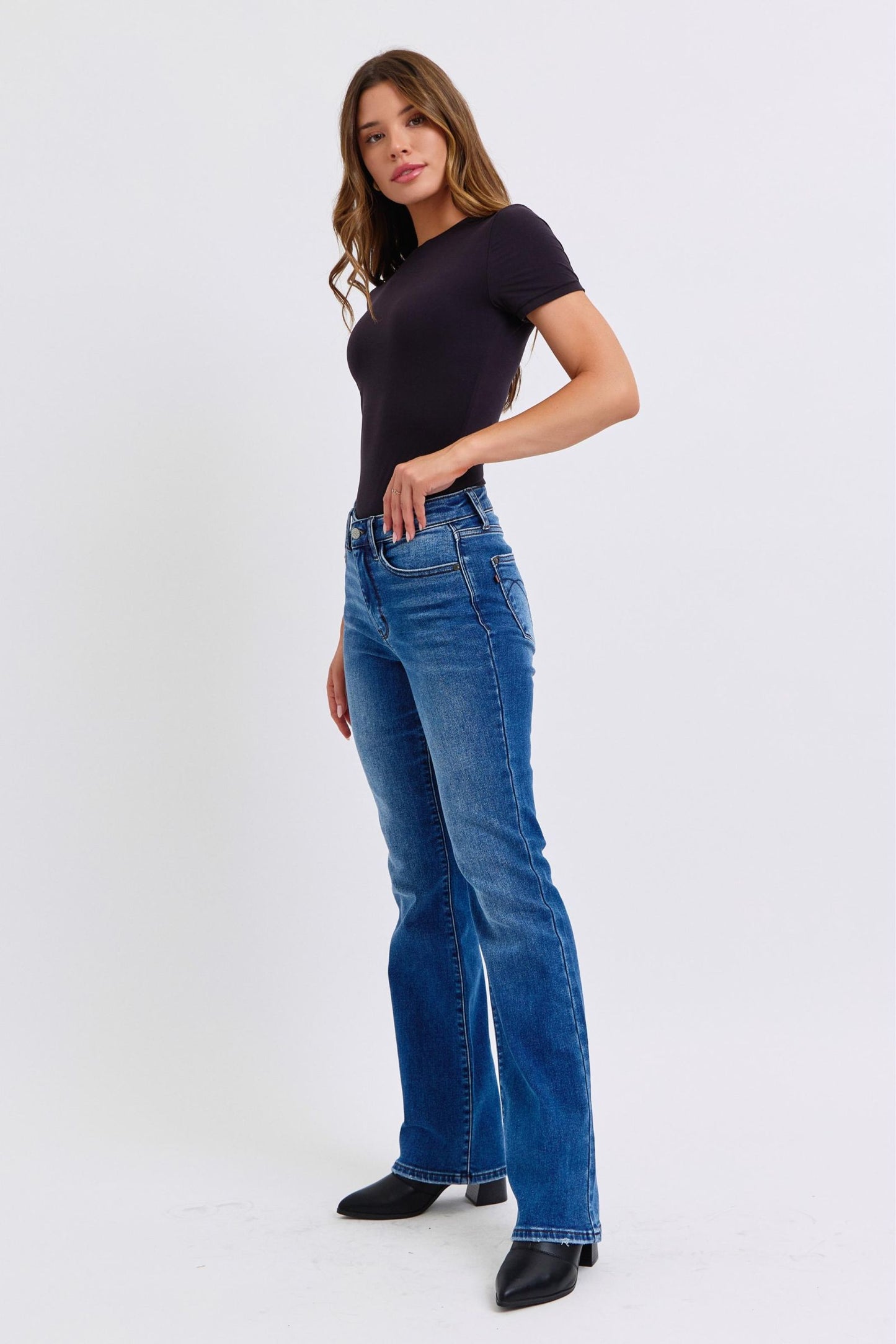 Judy Blue Mid-Rise Bootcut Jeans with thermal Lining. Featuring a mid-rise waist that offers a comfortable and flattering fit, these jeans accentuate the natural waistline. 
The bootcut silhouette flares slightly at the leg opening, creating a classic and elongating look. 
Designed with a thin thermal lining, these jeans provide lightweight warmth, making them perfect for cooler days. Front left angle view