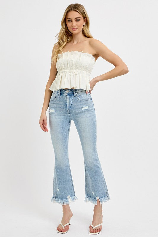 Risen Raw hem distressed cropped flare jeans offer a stylish and edgy twist to your denim collection. The cropped length hits above the ankle, making them perfect for showcasing your footwear. The flare silhouette adds a retro and fun vibe to the jeans, while the distressed detailing gives them a cool and worn-in look. The raw hem finish adds a touch of casual and laid-back charm to the jeans, making them ideal for a relaxed yet trendy outfit. Front view