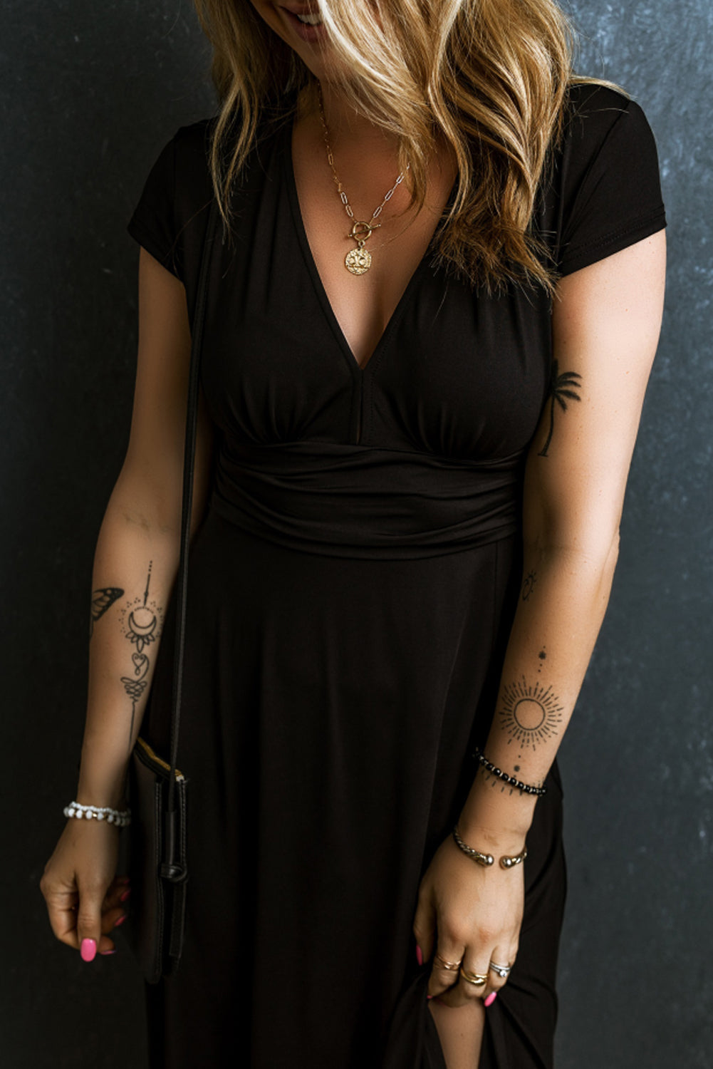 Woman wearing a black Maxi Dress with Short Sleeves, Shirred High Waist, V Neck. Close up of front upper body