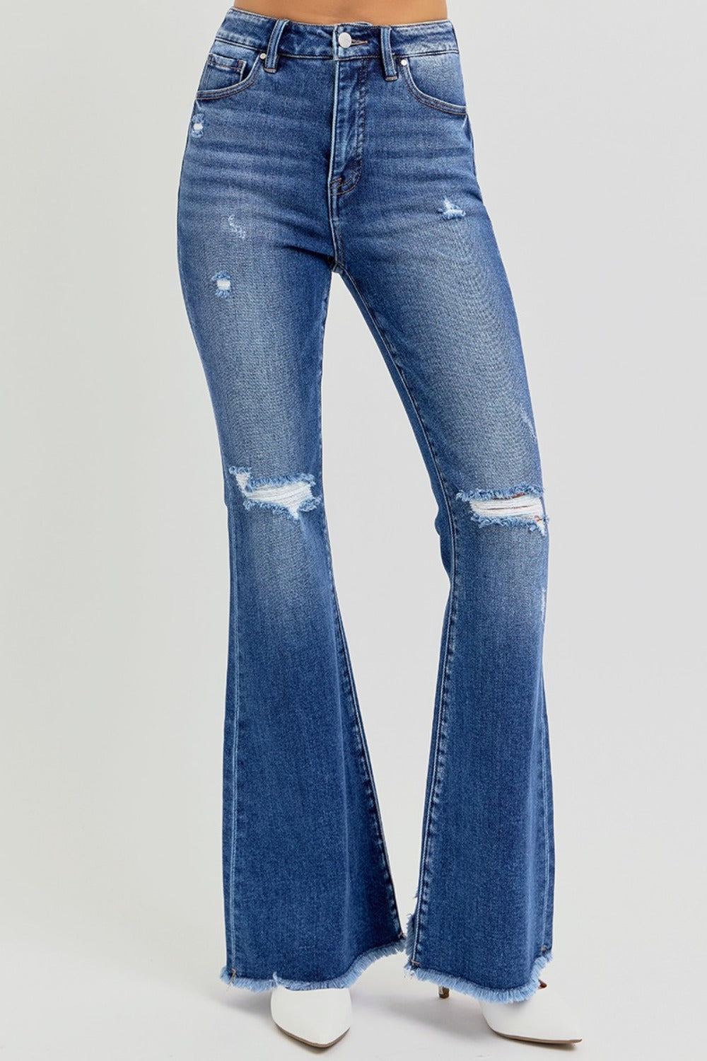 The Risen high rise distressed raw hem flare jeans are a trendy and stylish addition to your wardrobe. Featuring a flattering high-rise fit, these jeans offer a comfortable and supportive silhouette. The distressed detailing adds a touch of edge, while the raw hem gives them a modern, unfinished look. The flare leg creates a retro vibe, making them perfect for pairing with ankle boots or heels. Ideal for casual outings or dressed-up occasions, these jeans combine style with versatility! Front view