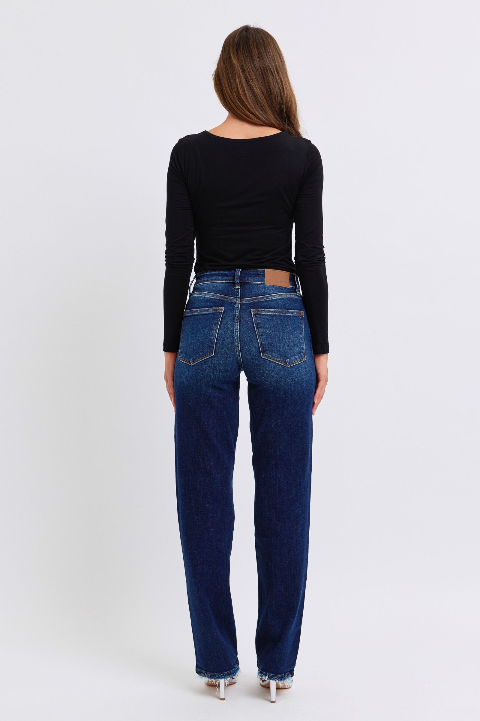 Judy Blue Raw Hem Straight Leg Jeans are a versatile and timeless addition to your wardrobe. The raw hem adds a touch of edge, while the straight leg style offers a flattering silhouette. Perfect for both casual and dressy looks, these jeans are a must-have for any fashion-forward individual. Back view
