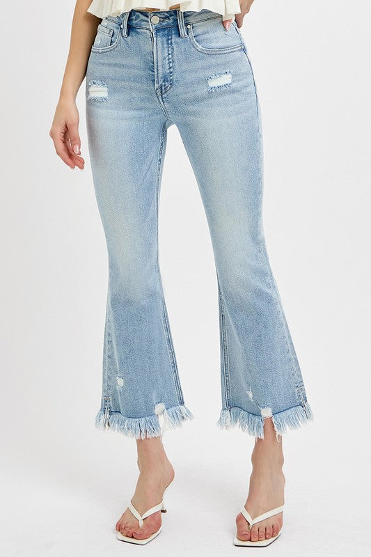 Risen Raw hem distressed cropped flare jeans offer a stylish and edgy twist to your denim collection. The cropped length hits above the ankle, making them perfect for showcasing your footwear. The flare silhouette adds a retro and fun vibe to the jeans, while the distressed detailing gives them a cool and worn-in look. The raw hem finish adds a touch of casual and laid-back charm to the jeans, making them ideal for a relaxed yet trendy outfit. Front view