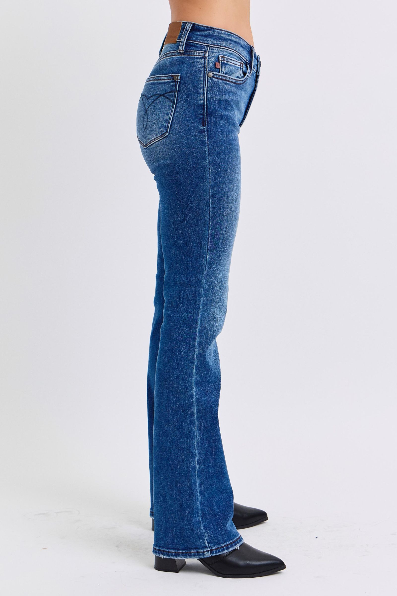 Judy Blue Mid-Rise Bootcut Jeans with thermal Lining. Featuring a mid-rise waist that offers a comfortable and flattering fit, these jeans accentuate the natural waistline. 
The bootcut silhouette flares slightly at the leg opening, creating a classic and elongating look. 
Designed with a thin thermal lining, these jeans provide lightweight warmth, making them perfect for cooler days. Right side view