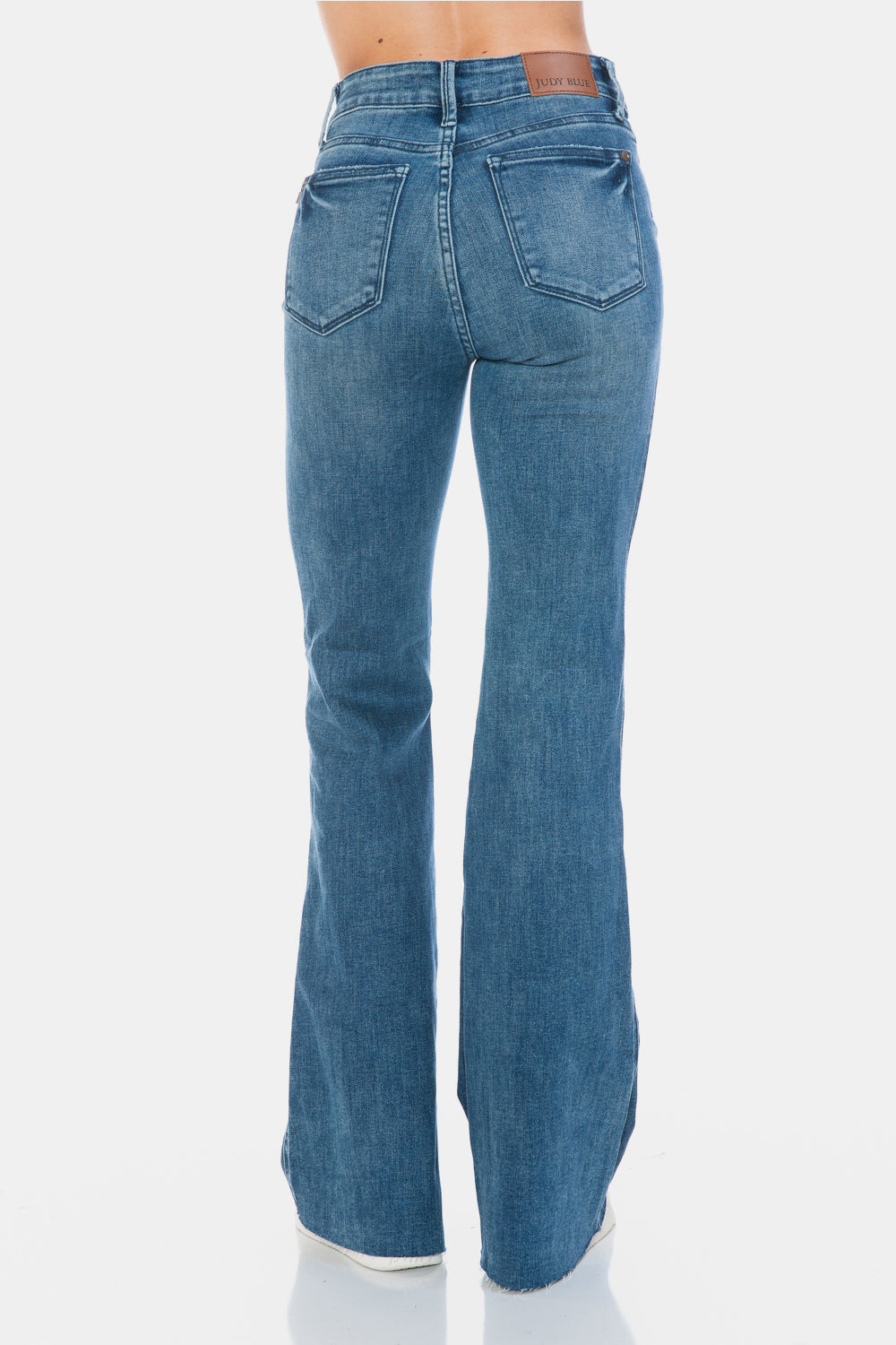 Judy Blue Mid-Rise Tummy Control Vintage Wash Cut Hem Flare is a stylish and flattering pair of jeans. With its tummy control feature, it helps create a streamlined silhouette. The vintage wash gives it a classic and timeless look. The cut hem flare adds a modern twist to the design. Perfect for any occasion, these jeans are versatile and comfortable to wear. Elevate your wardrobe with the Mid-Rise Tummy Control Vintage Wash Cut Hem Flare! Back view