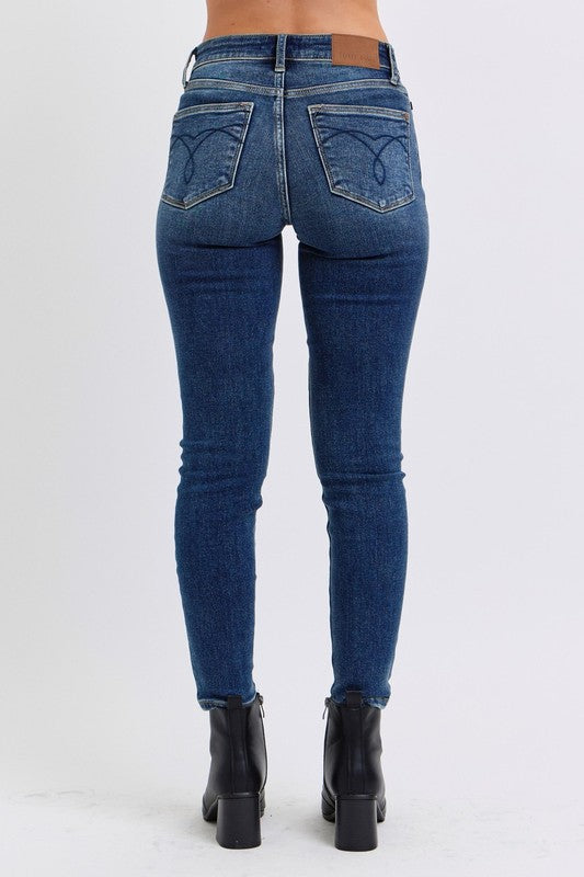 Judy Blue Mid-Rise Waist Skinny Jeans with Pockets are a versatile and essential piece for any wardrobe. With a flattering mid-rise waist and slimming skinny fit, these jeans create a sleek and stylish look. 
The addition of a thin thermal lining provides lightweight warmth, making them perfect for cooler days, while the pockets offer both functionality and casual flair. Back view
