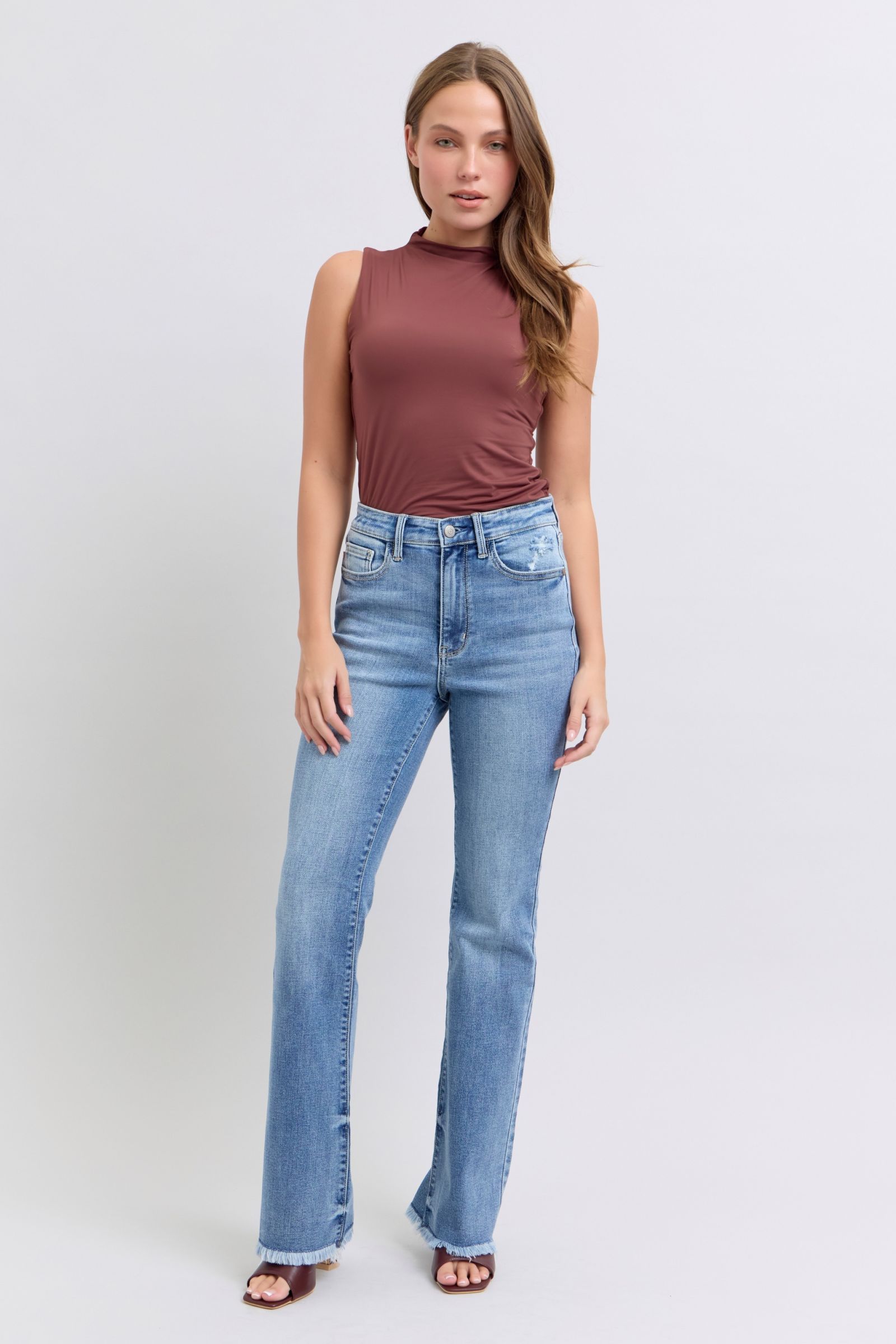Judy Blue Raw hem high rise bootcut jeans are a trendy and stylish denim option for a fashionable look. These jeans feature a high-rise waist that sits above the natural waistline, elongating the legs and providing a flattering silhouette. The bootcut style flares out slightly from the knee down, creating a balanced and vintage-inspired look. The raw hem detail at the bottom adds a modern and edgy touch to the jeans, giving them a unique and on-trend appearance.  Front view