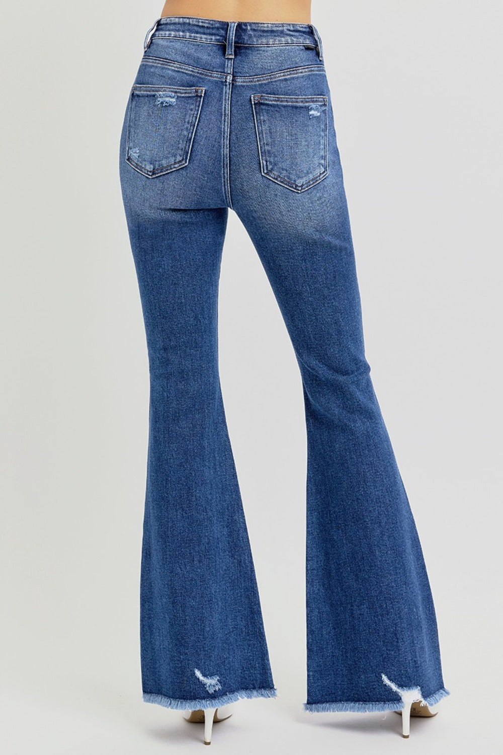 The Risen high rise distressed raw hem flare jeans are a trendy and stylish addition to your wardrobe. Featuring a flattering high-rise fit, these jeans offer a comfortable and supportive silhouette. The distressed detailing adds a touch of edge, while the raw hem gives them a modern, unfinished look. The flare leg creates a retro vibe, making them perfect for pairing with ankle boots or heels. Ideal for casual outings or dressed-up occasions, these jeans combine style with versatility! Back view
