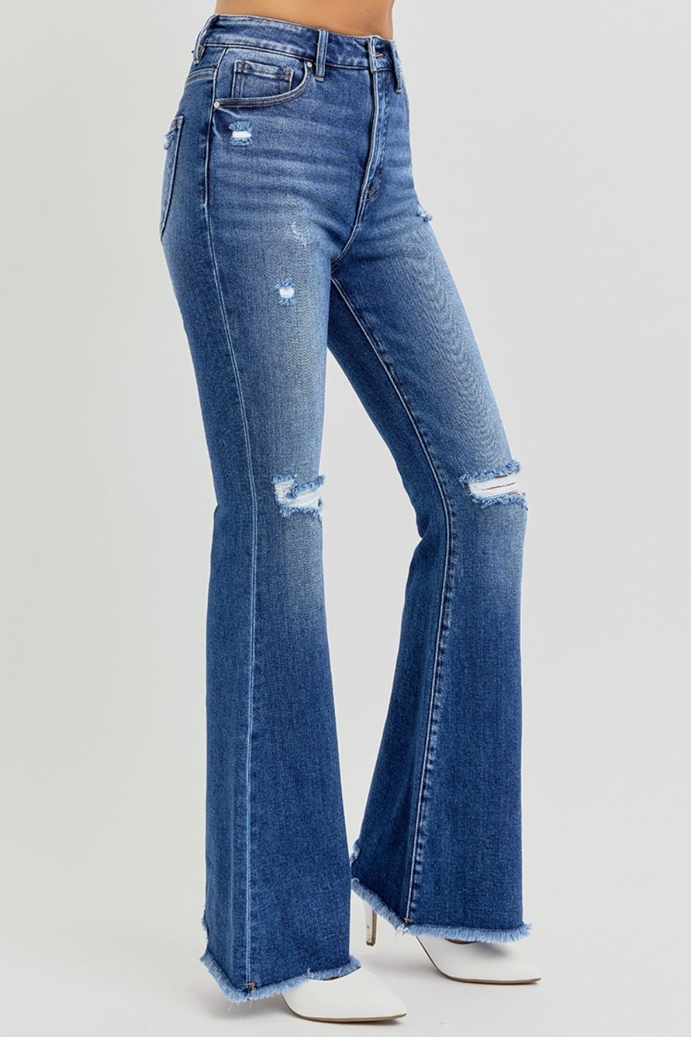 The Risen high rise distressed raw hem flare jeans are a trendy and stylish addition to your wardrobe. Featuring a flattering high-rise fit, these jeans offer a comfortable and supportive silhouette. The distressed detailing adds a touch of edge, while the raw hem gives them a modern, unfinished look. The flare leg creates a retro vibe, making them perfect for pairing with ankle boots or heels. Ideal for casual outings or dressed-up occasions, these jeans combine style with versatility! Front right view
