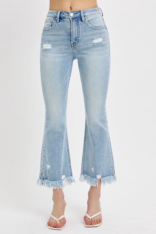 Risen Raw hem distressed cropped flare jeans offer a stylish and edgy twist to your denim collection. The cropped length hits above the ankle, making them perfect for showcasing your footwear. The flare silhouette adds a retro and fun vibe to the jeans, while the distressed detailing gives them a cool and worn-in look. The raw hem finish adds a touch of casual and laid-back charm to the jeans, making them ideal for a relaxed yet trendy outfit. Front view